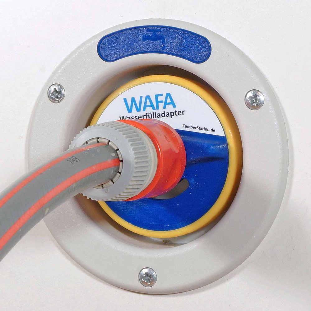 WAFA 3 mit gelbem Rand im grauen Einfüllstutzen eines Wohnmobils, daran ein Schlauch mit orangefarbener Kupplung