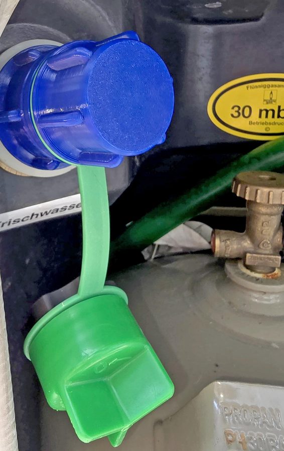 Kleiner Tankstutzen mit aufgeschraubtem blauem WAFA 8, darunter hängt am Band der grüne Originaldeckel